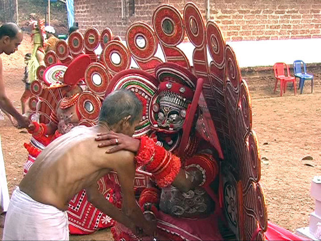 Theyyam: Sasthappan: Receiving a blessing by Sasthappan, a mistreated boy who went rampage and was turned to a deity Theyyam: Sasthappan: Receiving a blessing by Sasthappan, a mistreated boy who went rampage and was turned to a deity